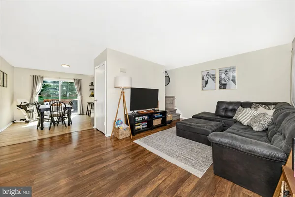 a living room with furniture and a flat screen tv with wooden floor