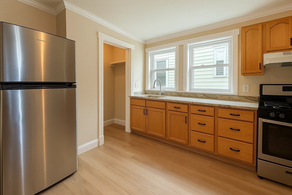 a kitchen with white cabinets and refrigerator