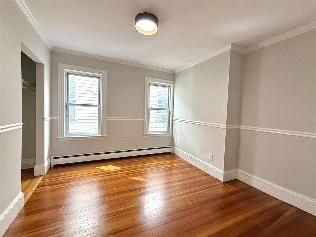 19 Howell Street, Unit 2 Boston, MA 02125 - Photo 12 of 16 an empty room with wooden floor and windows
