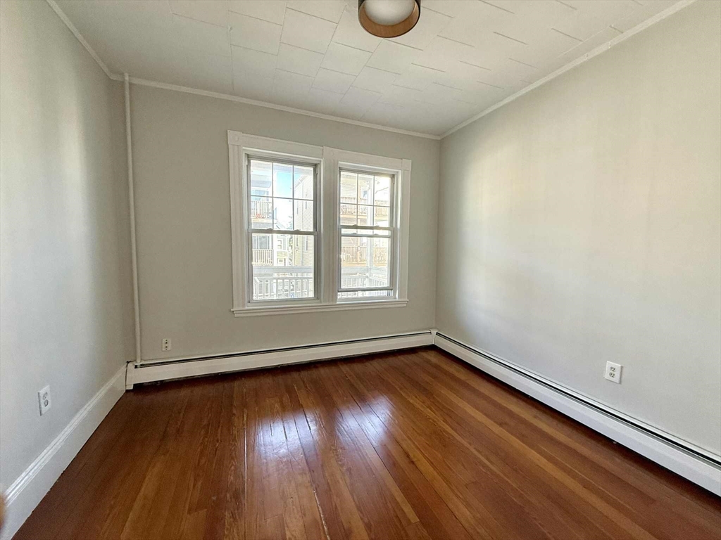 19 Howell Street, Unit 2 Boston, MA 02125 - Photo 13 of 16 an empty room with wooden floor and windows