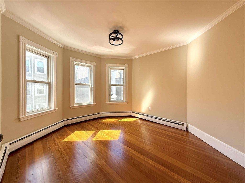 19 Howell Street, Unit 2 Boston, MA 02125 - Photo 5 of 16 an empty room with wooden floor and windows