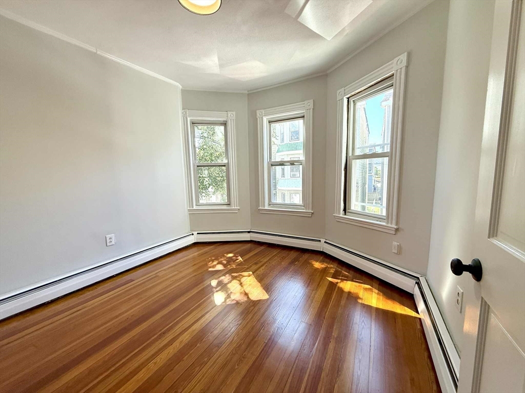 19 Howell Street, Unit 2 Boston, MA 02125 - Photo 6 of 16 a view of an empty room with wooden floor and a window