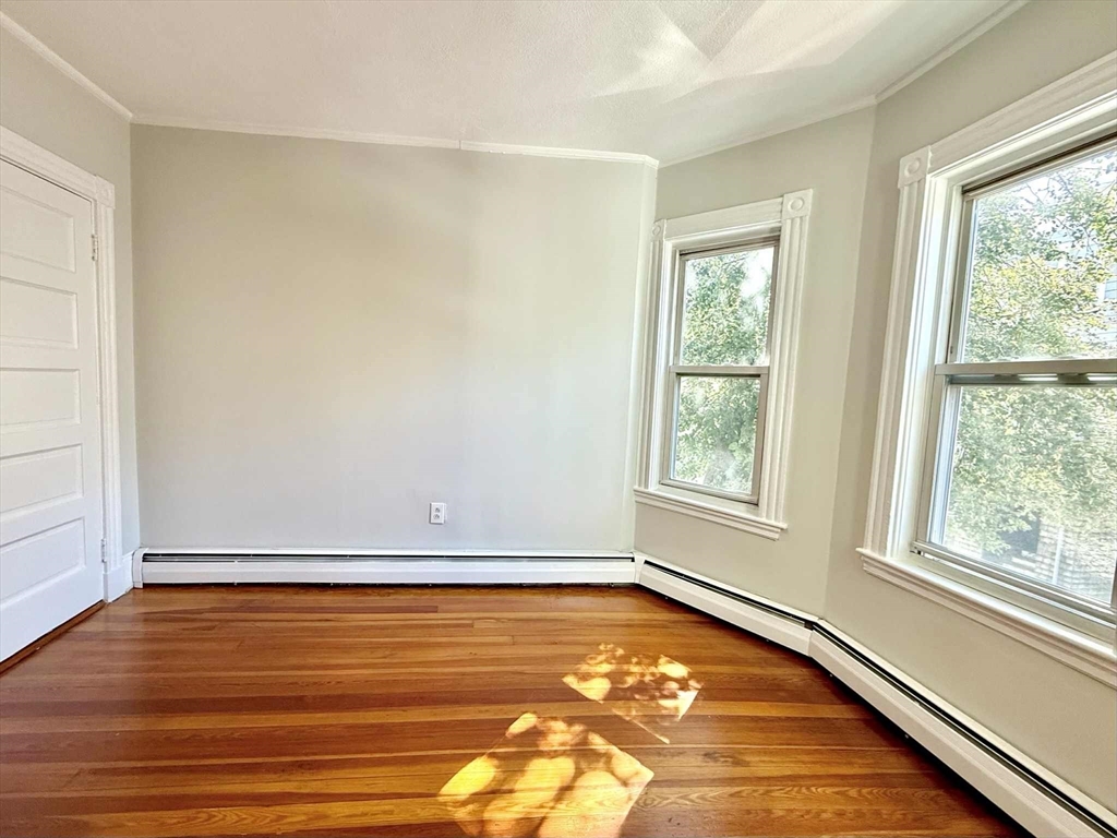 19 Howell Street, Unit 2 Boston, MA 02125 - Photo 7 of 16 a view of an empty room with a window and wooden floor