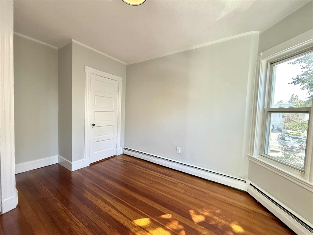 19 Howell Street, Unit 2 Boston, MA 02125 - Photo 8 of 16 an empty room with wooden floor and windows