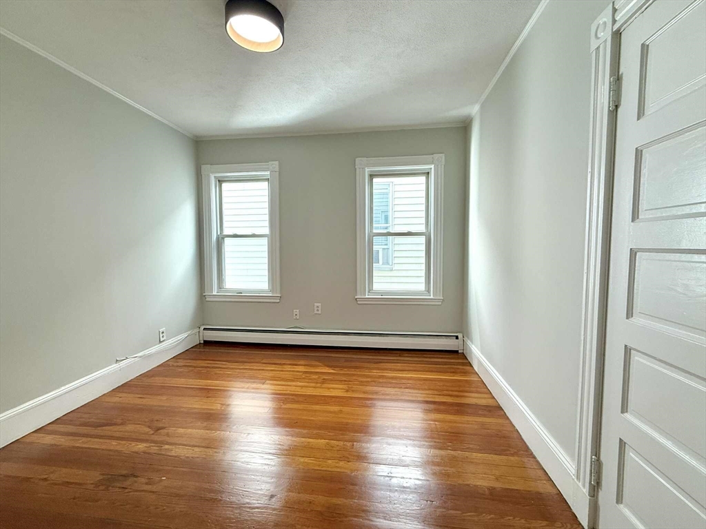 19 Howell Street, Unit 2 Boston, MA 02125 - Photo 9 of 16 an empty room with wooden floor and windows