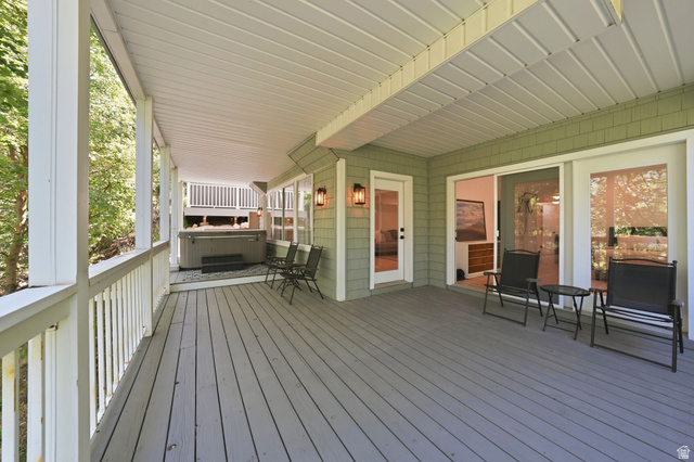 1979 Cave Hollow Way Bountiful, UT 84010 - Photo 43 of 59 Expansive covered deck featuring wood-finish flooring, a built-in hot tub, and multiple exterior access points