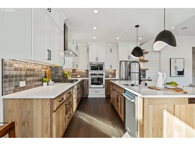 a kitchen with stainless steel appliances kitchen island a sink and a refrigerator