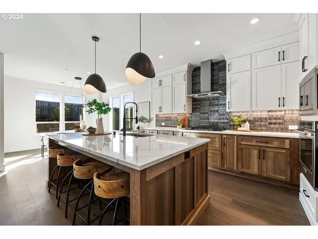 a kitchen with kitchen island granite countertop a sink a stove and a refrigerator