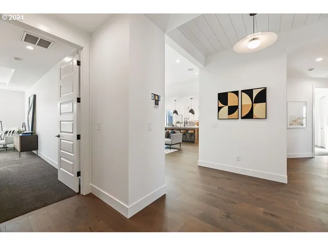 a view of a hallway with wooden floor and a living room