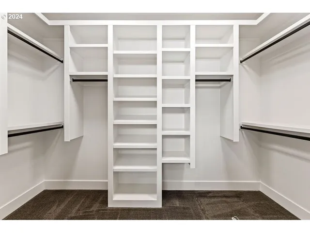 a view of walk in closet with empty racks