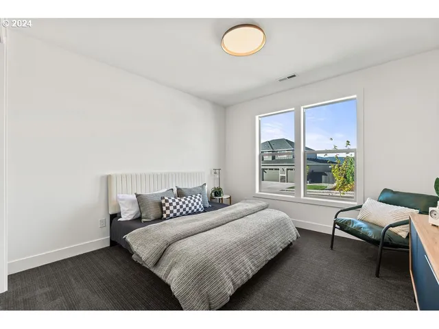 a bedroom with a bed chair and window