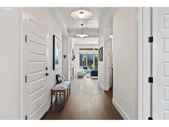 a hallway with wooden floor table and chairs