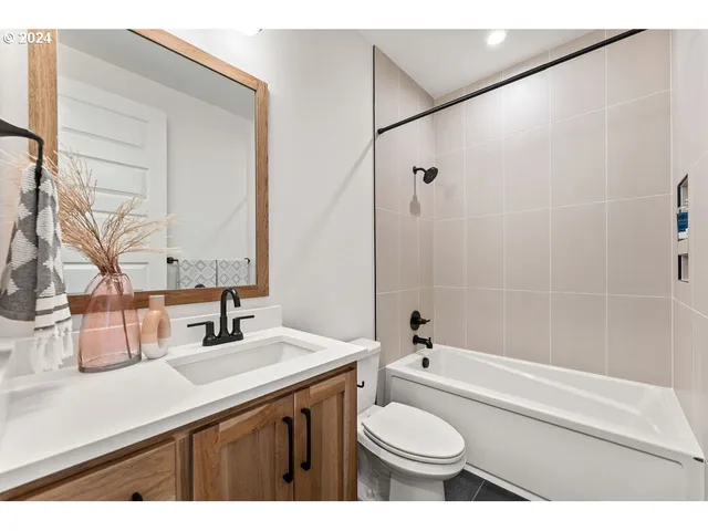 a bathroom with a sink a toilet a mirror and shower