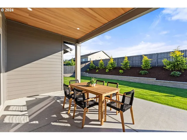 a patio with glass top table and chairs