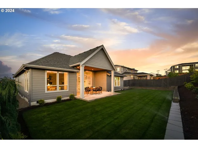 a front view of a house with a yard and trees