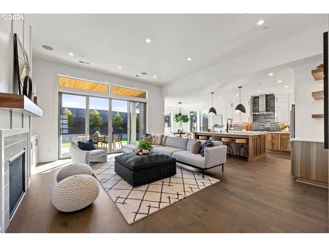 a living room with fireplace furniture and a large window