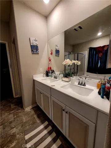 a bathroom with double vanity sink and a mirror
