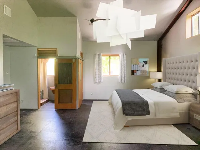 a bedroom with a large bed and wooden floor