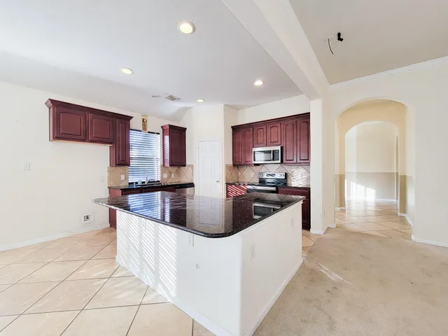 a kitchen with stainless steel appliances granite countertop a sink and a refrigerator