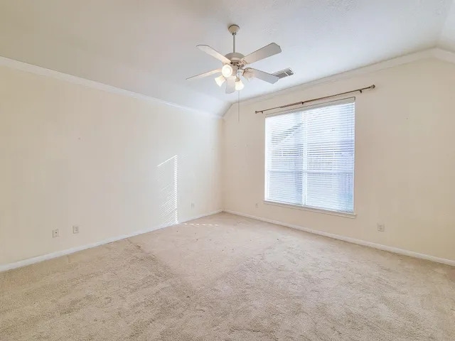 an empty room with windows and fan