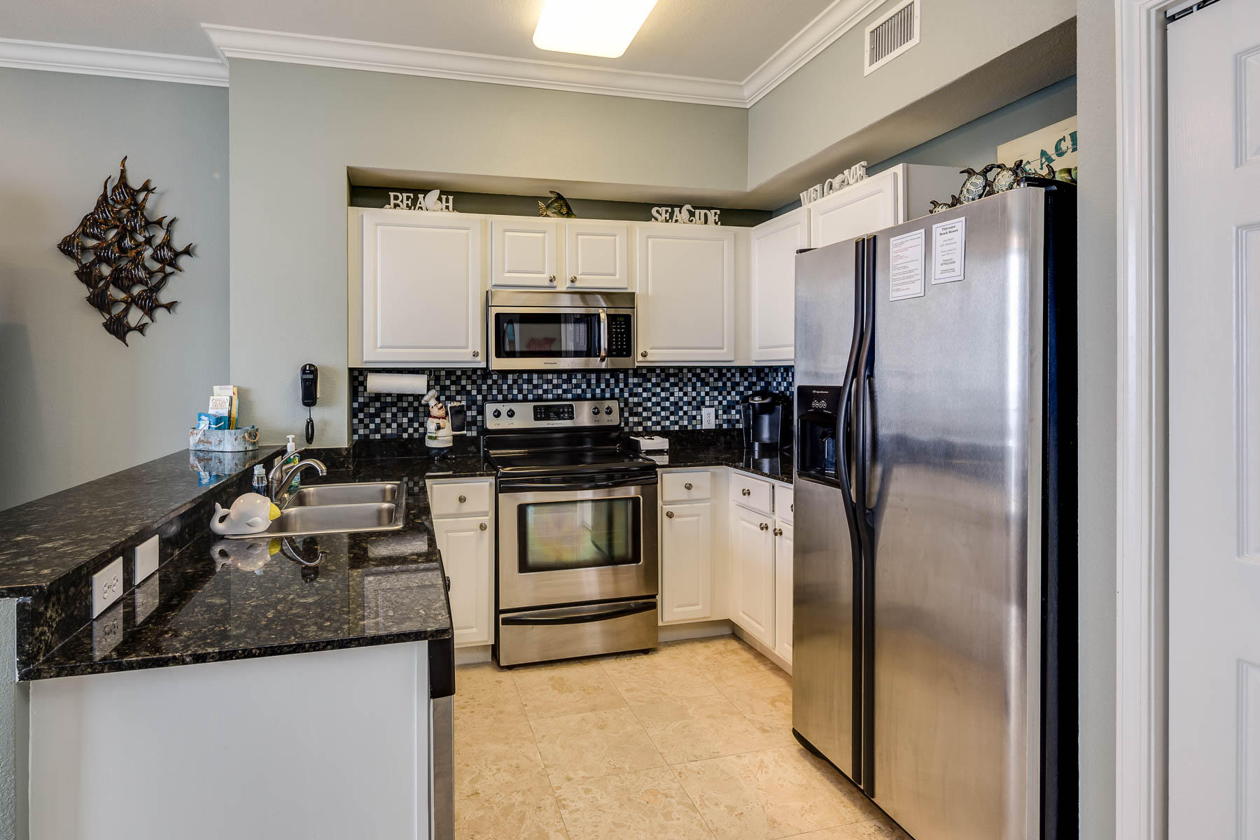 16819 Front Beach Road, Unit 3011 Panama City Beach, FL 32413 - Photo 6 of 28 a kitchen with appliances a counter space and a sink