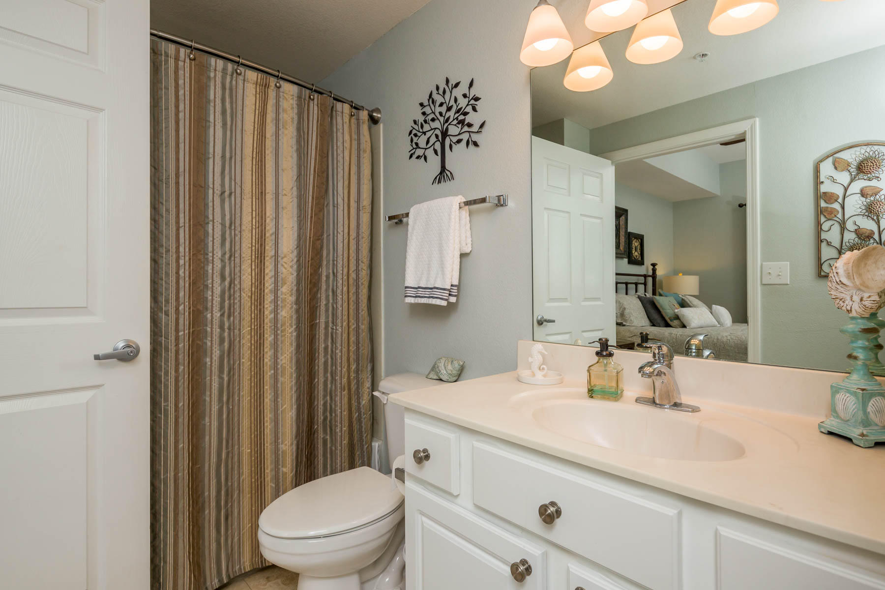 16819 Front Beach Road, Unit 3011 Panama City Beach, FL 32413 - Photo 10 of 28 a bathroom with a sink a toilet and shower curtain