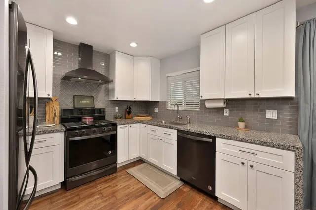 a kitchen with stainless steel appliances granite countertop a stove a sink and a refrigerator
