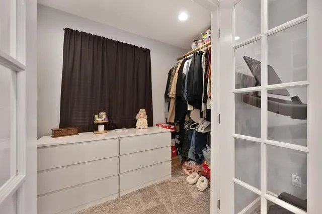 a view of walk in closet with clothes and shoes