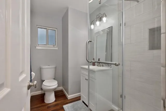 a bathroom with a toilet sink a mirror and vanity