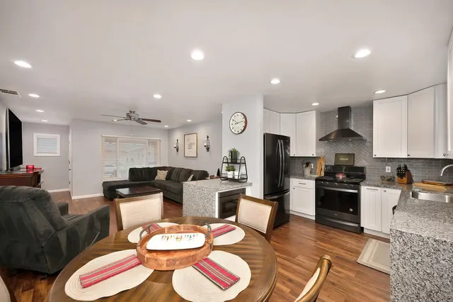 a living room with stainless steel appliances kitchen island granite countertop furniture and a view of kitchen
