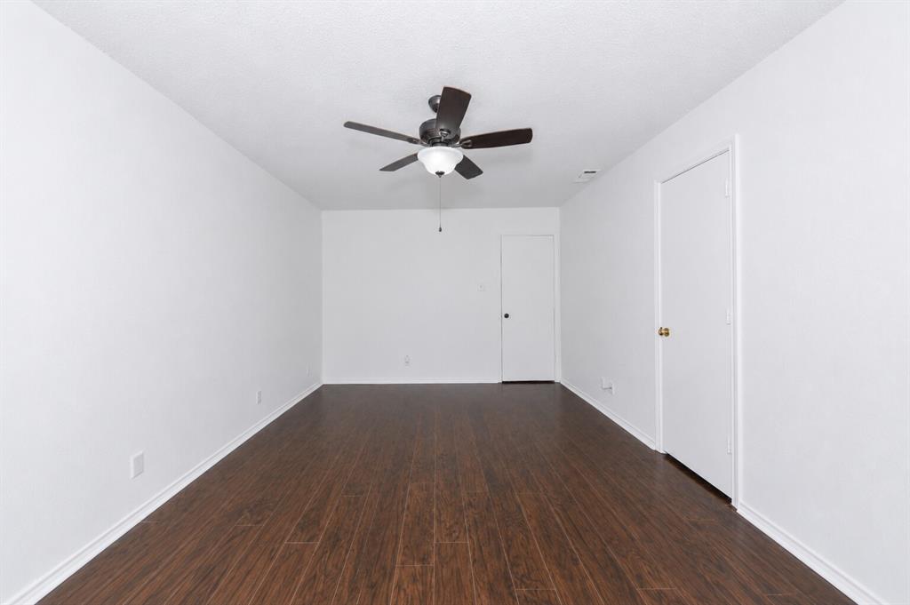 1001 Rosebud Drive Azle, TX 76020 - Photo 23 of 36 Spacious interior room featuring dark wood-finish flooring, crisp white walls, and a ceiling fan with integrated lighting