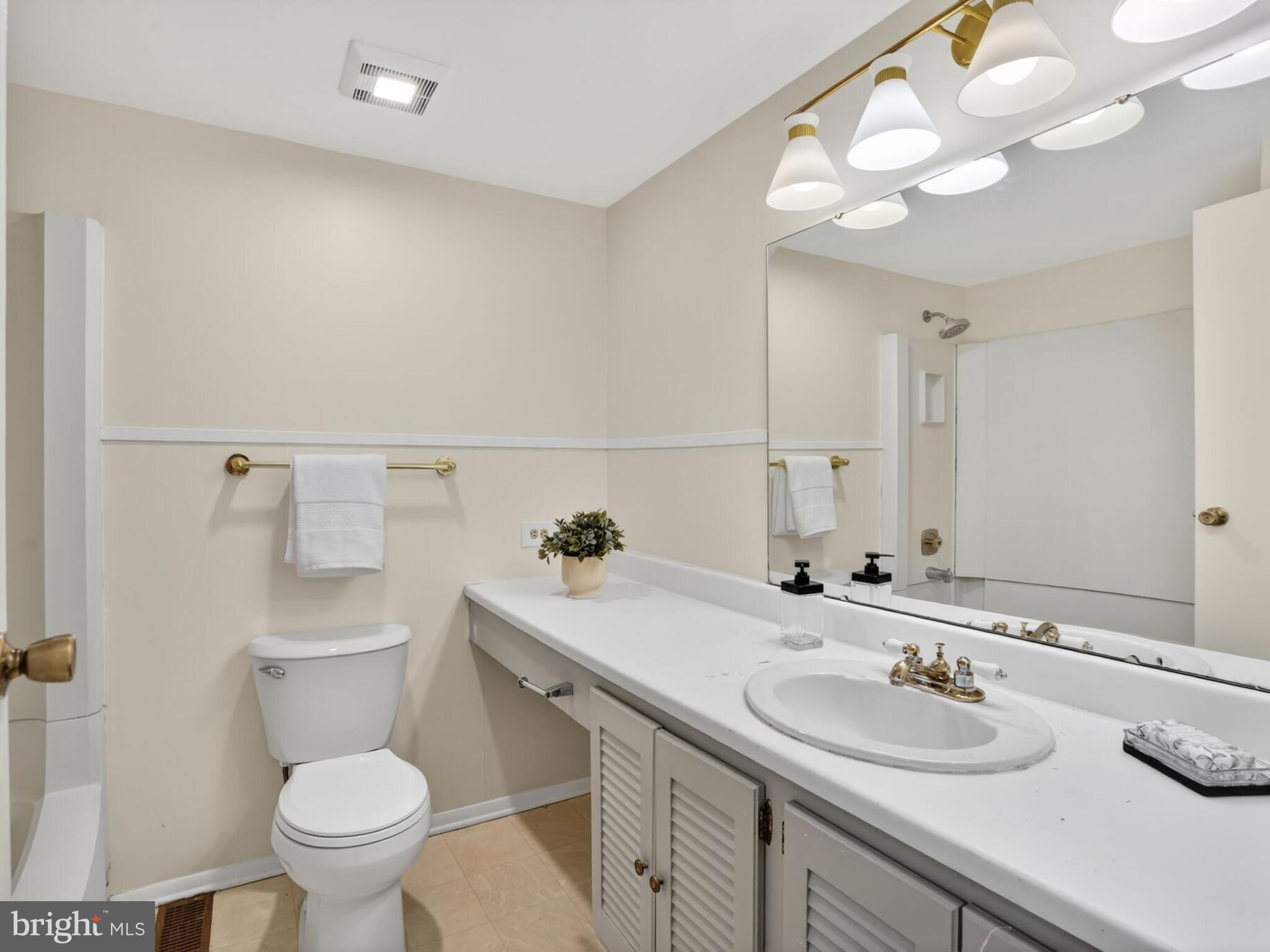 5914 Freds Oak Road Burke, VA 22015 - Photo 21 of 30 a bathroom with a granite countertop toilet sink and mirror