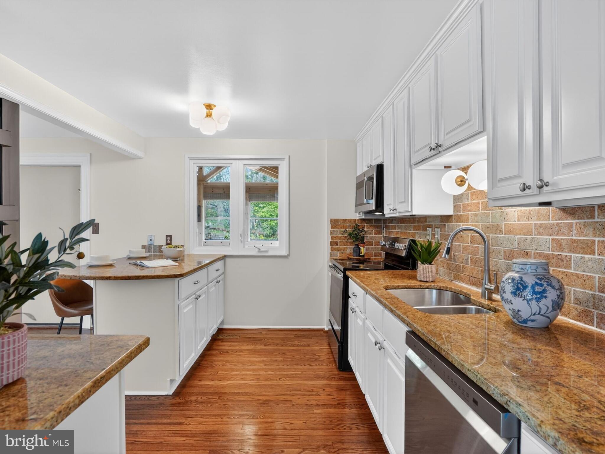 5914 Freds Oak Road Burke, VA 22015 - Photo 10 of 30 a kitchen with stainless steel appliances granite countertop a sink stove and cabinets