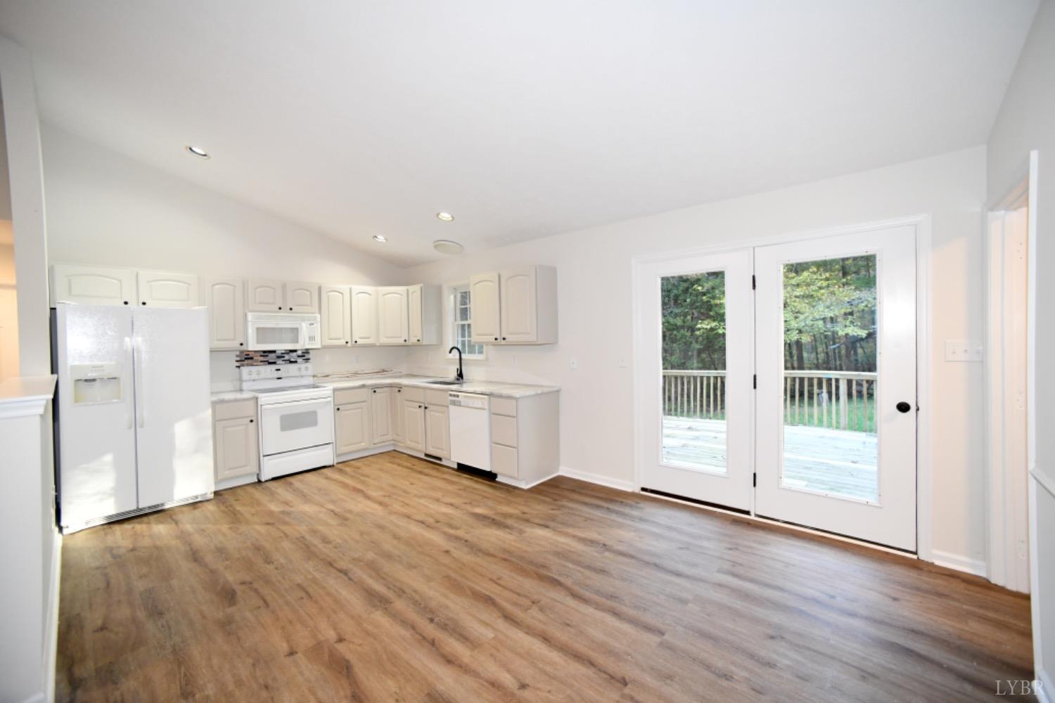 299 Sunset Ridge Drive Farmville, VA 23901 - Photo 22 of 38 a large white open kitchen with white cabinets and wooden floor