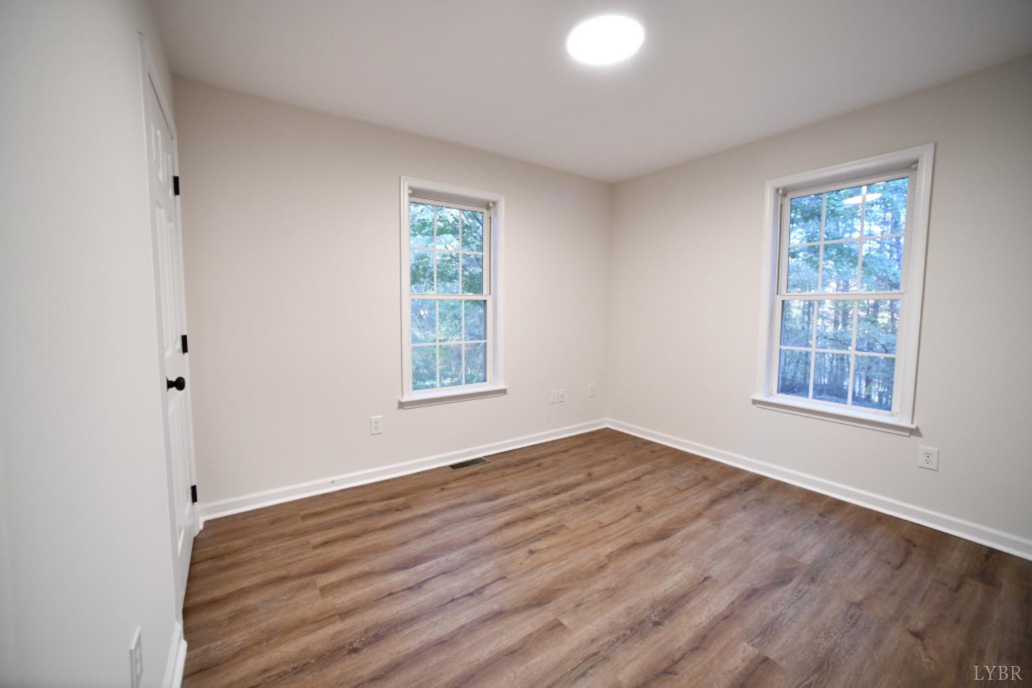 299 Sunset Ridge Drive Farmville, VA 23901 - Photo 36 of 38 an empty room with wooden floor and windows