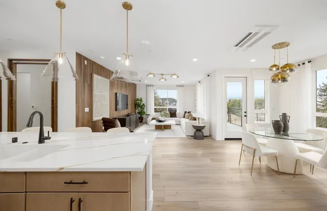 a living room with kitchen island furniture and a chandelier