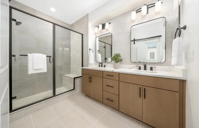 a spacious bathroom with a double vanity sink mirror double and shower