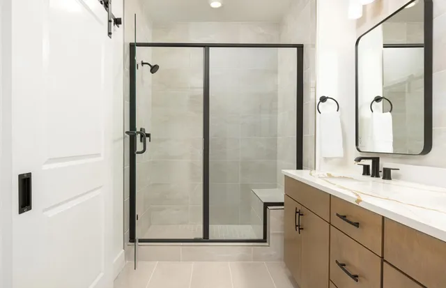 a bathroom with a double vanity sink mirror and shower