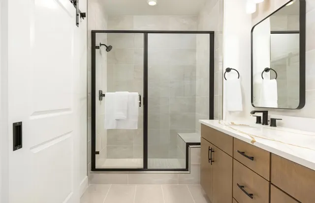 a bathroom with a double vanity sink mirror and shower