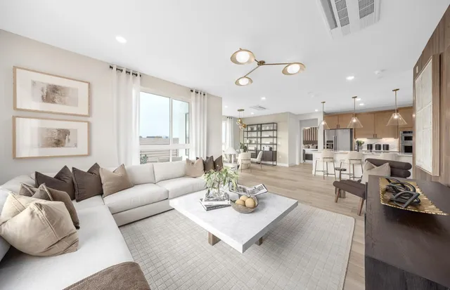 a living room with furniture kitchen view and a large window