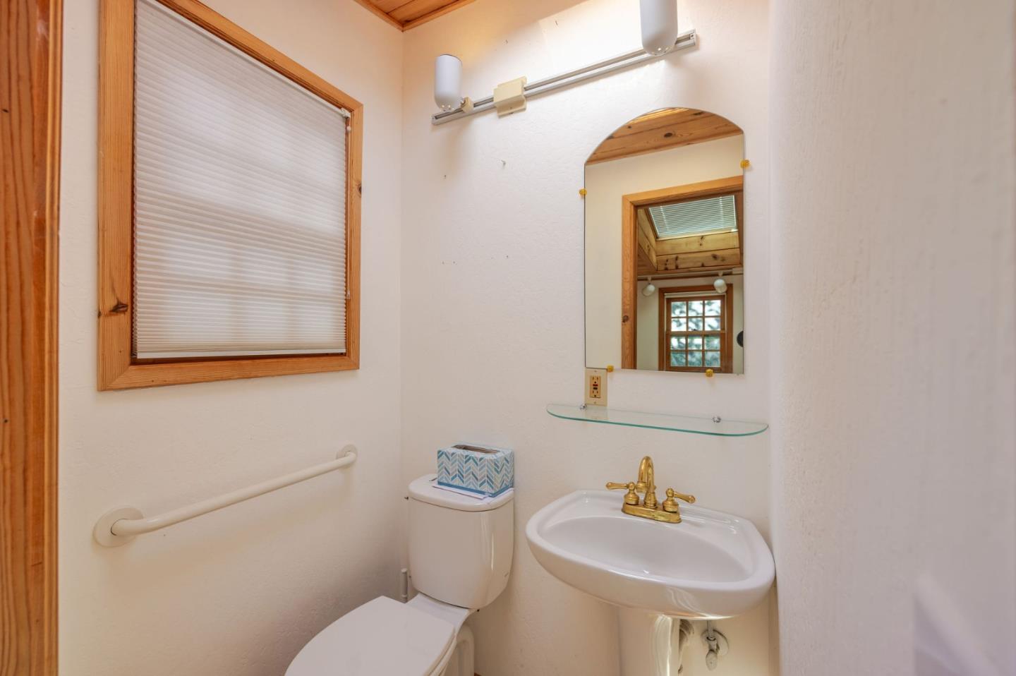 1009 Miramontes Street Half Moon Bay, CA 94019 - Photo 20 of 69 a bathroom with a toilet sink and mirror