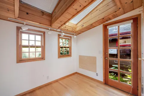 a view of a room with wooden floor and furniture