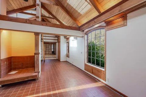 a view of a hallway with wooden floor and windows