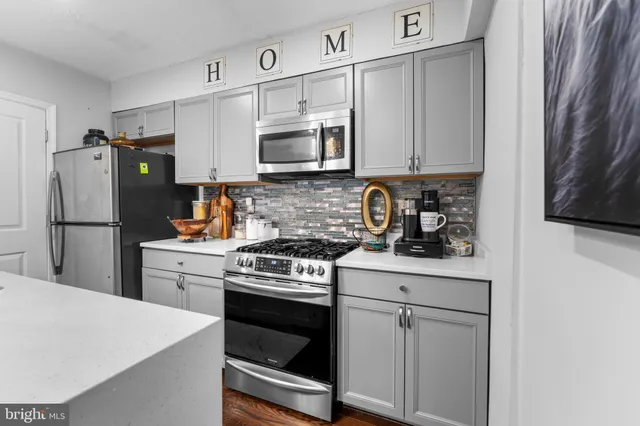 a kitchen with stainless steel appliances white cabinets and white appliances