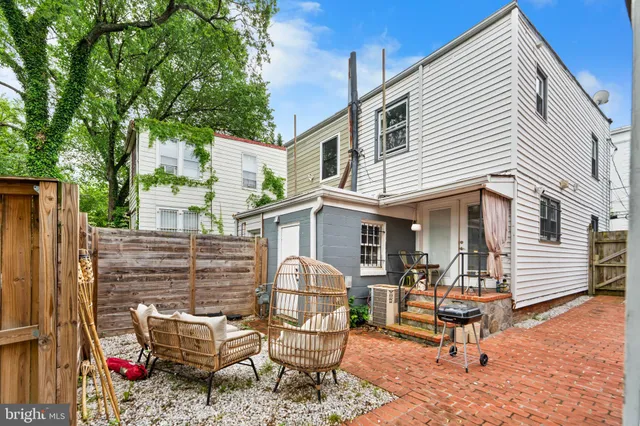 a view of a white house with many windows table and chairs