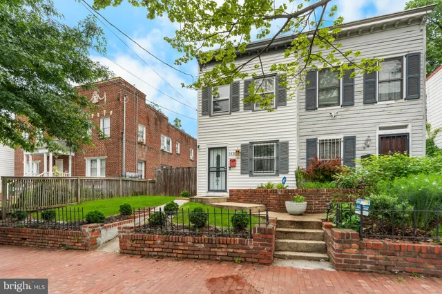a front view of a house with garden and plants