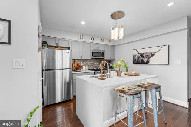 a kitchen with refrigerator a sink and chairs