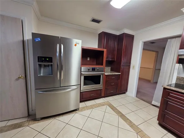a kitchen with stainless steel appliances granite countertop a refrigerator and a stove top oven