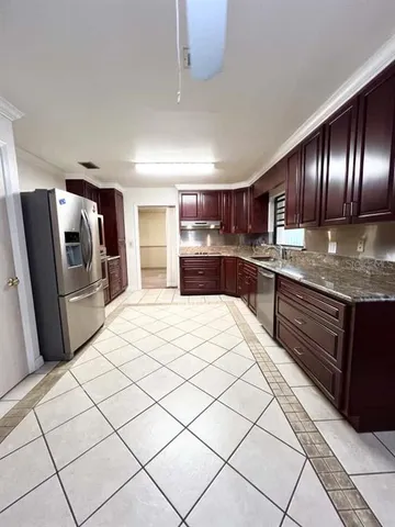 a kitchen with stainless steel appliances granite countertop a refrigerator and a stove