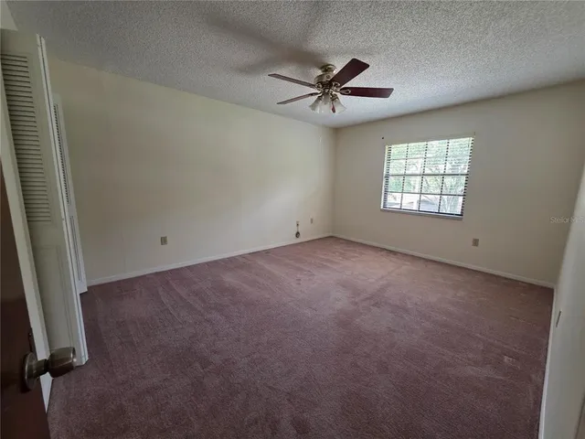 a view of empty room with ceiling fan